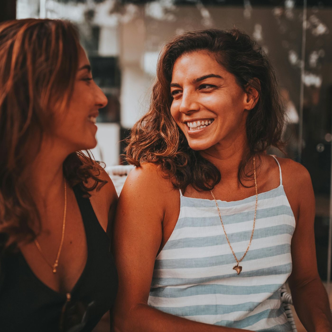 Two friends chatting at an outdoor café in Birley, reflecting simple, genuine conversations building friendships after 40.