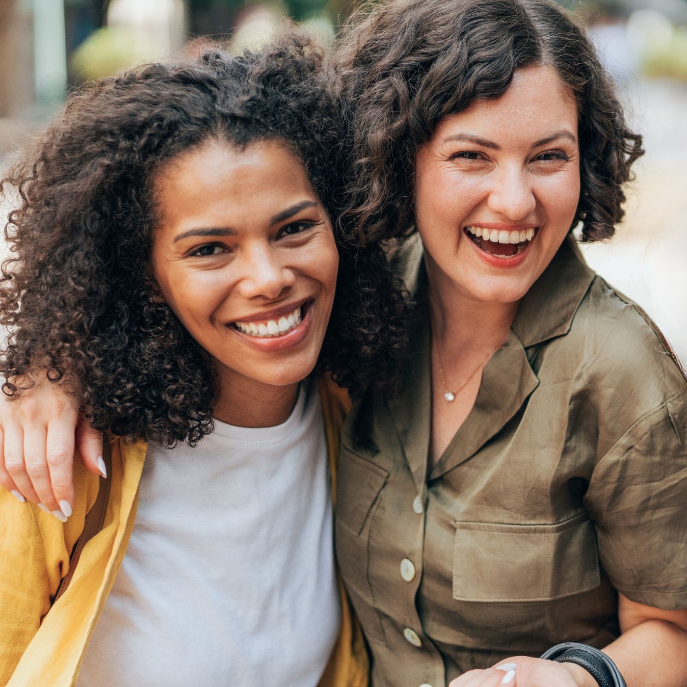 Two women laughing outdoors in Mosborough, capturing the joy of building new friendships later in life.