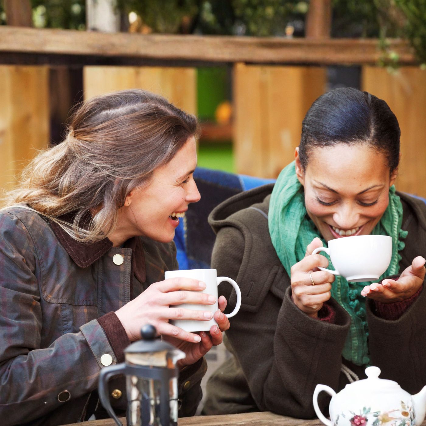Two women sharing warm drinks in Helston, reflecting the ease and depth that come with friendships after 40.