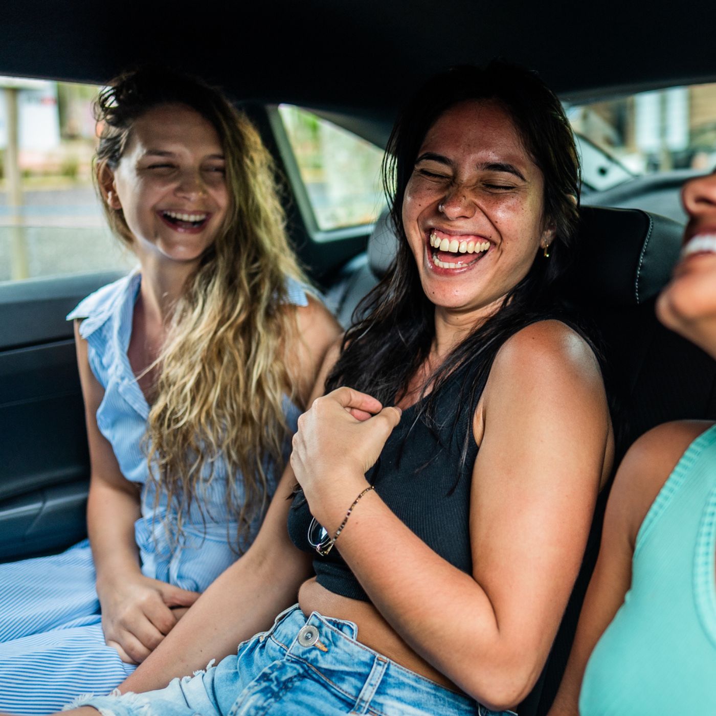 Three women laughing together in a car in a casual Hackney Central moment
