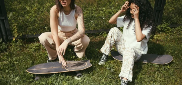 Two women with skateboards spending time together outdoors, illustrating UK friendship statistics.