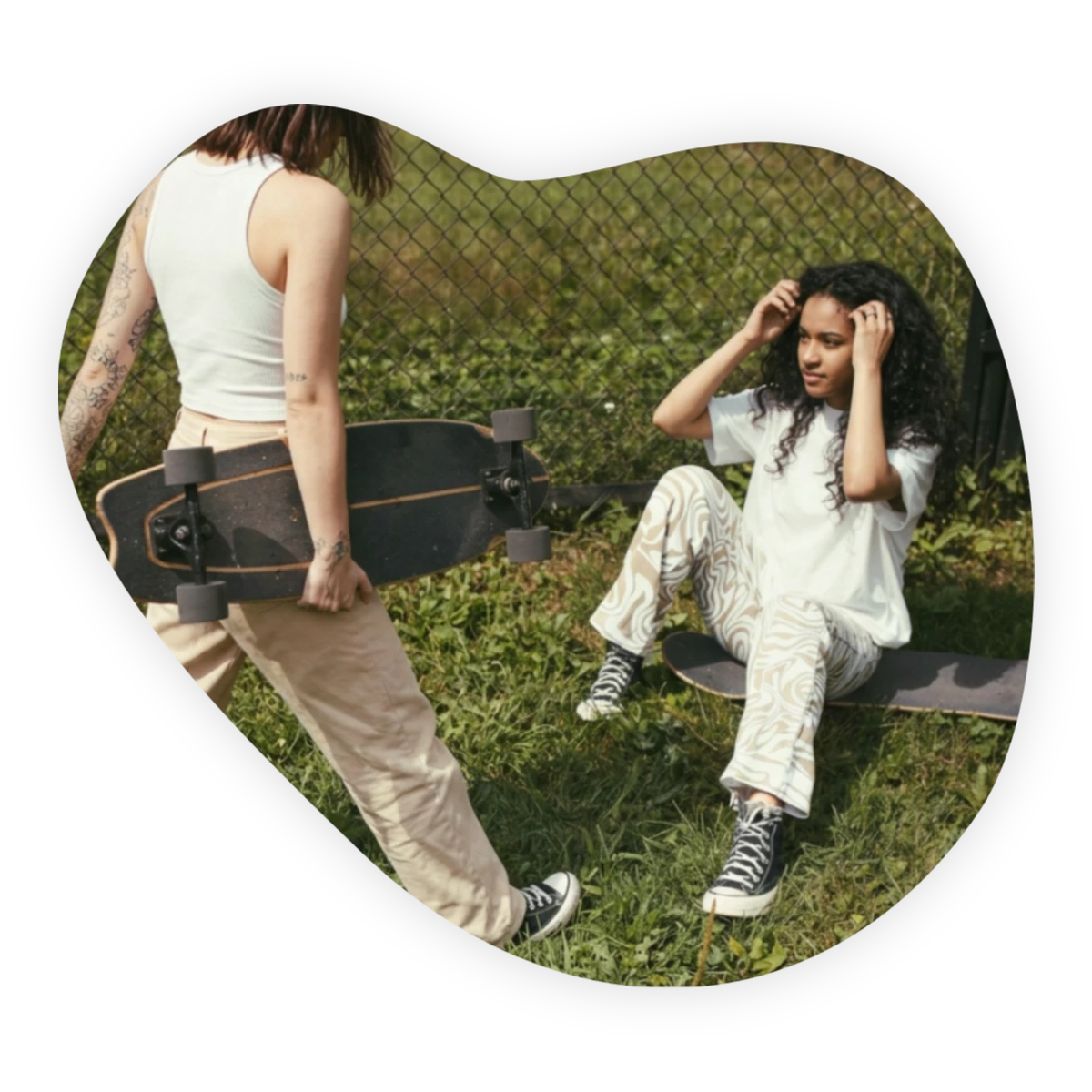 Two women with skateboards sharing a relaxed moment outdoors, illustrating UK friendship statistics.