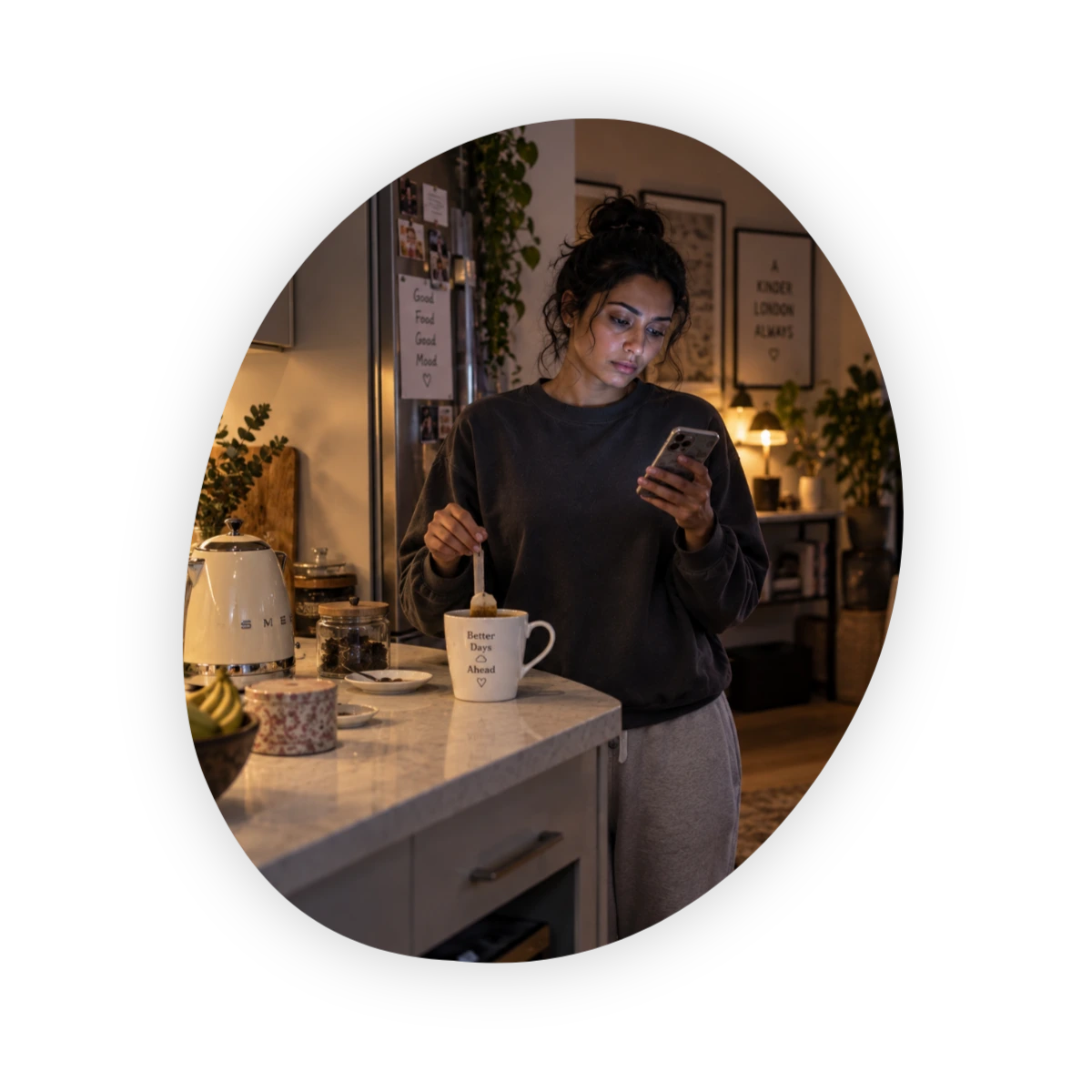 Woman alone in her kitchen checking her phone, a quiet moment of feeling lonely even with friends